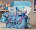 Gift box with Disney character design containing stationery items on a wooden surface.